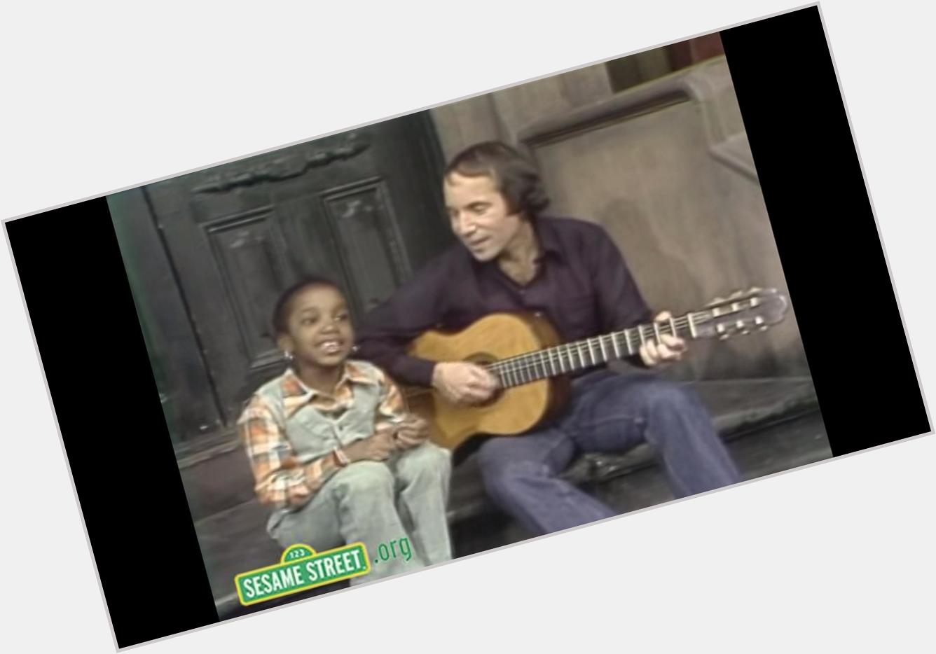 A little girl steals spotlight from birthday boy Paul Simon during 1977 visit to Sesame St.  